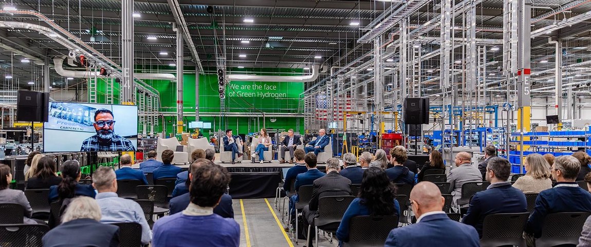 Audience gathered for Plug's investor symposium inside an active manufacturing facility.