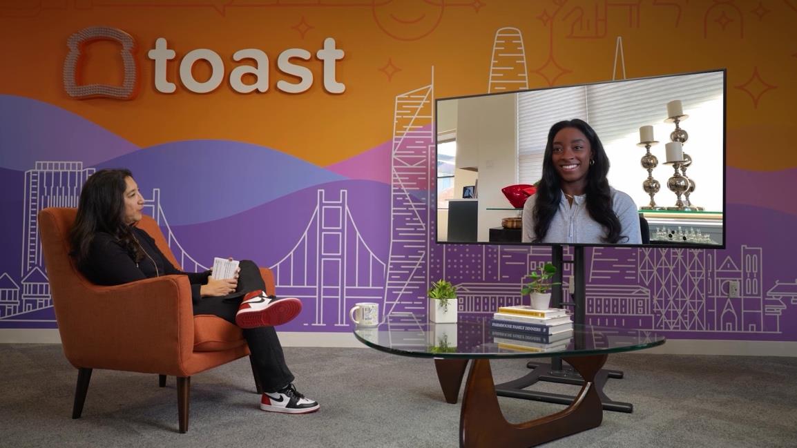 A live corporate presentation with remote contributors shown on the stage display.
